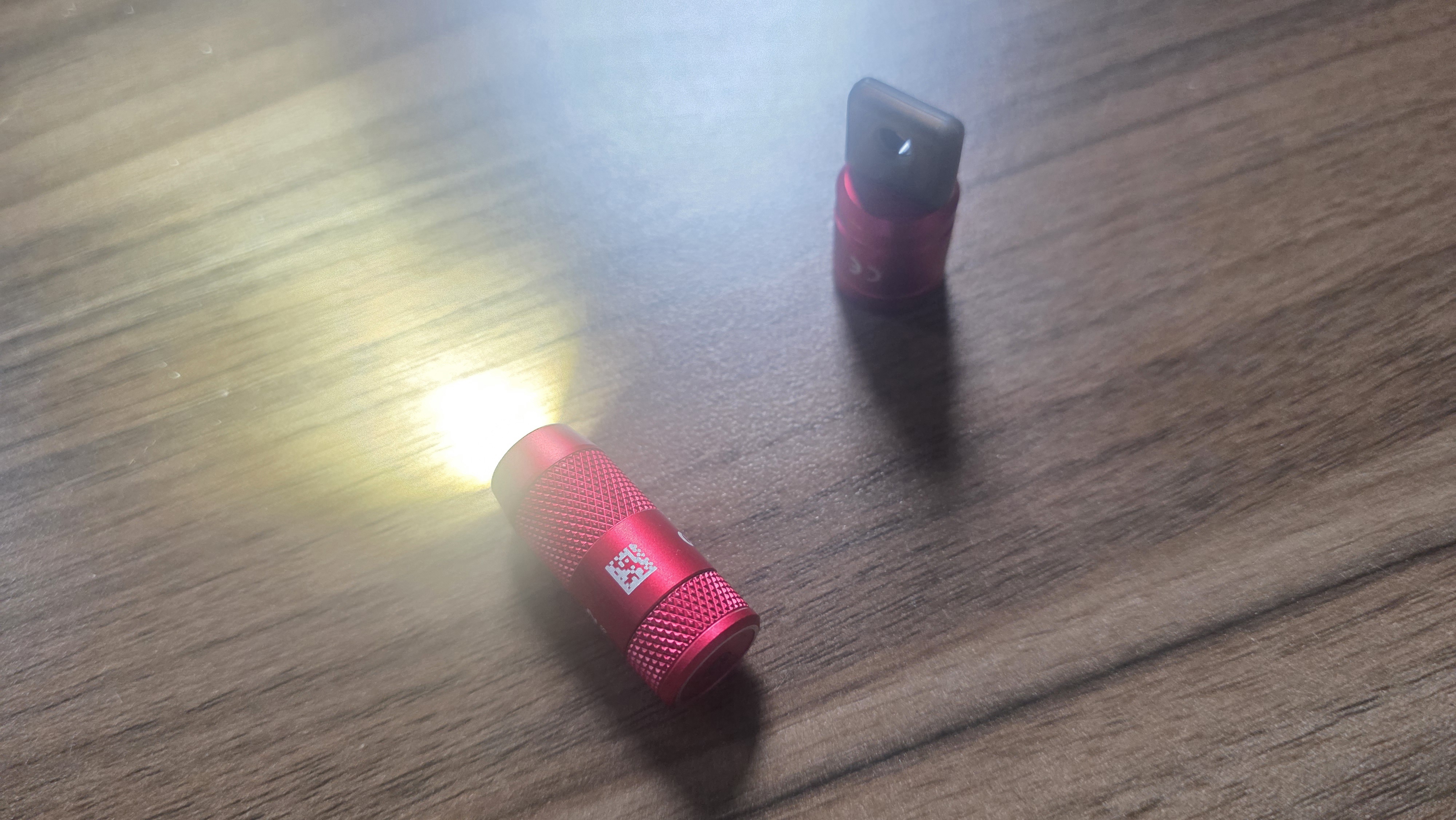 Olight Mini 2 red, shining, on a wood table
